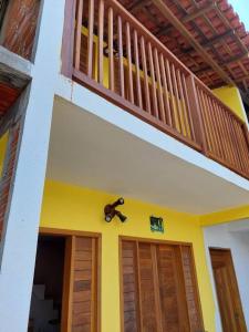 uma casa com varanda e duas portas em Casa na Praia com Super Piscina, em Condomínio Fechado. em São José de Ribamar