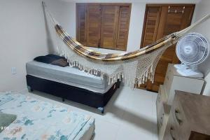 uma rede de descanso num quarto com uma cama e uma ventoinha em Casa na Praia com Super Piscina, em Condomínio Fechado. em São José de Ribamar