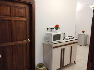 a kitchen with a microwave on top of a counter at Qurban Apartment in Al ‘Awālī