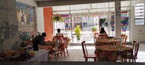 a group of people sitting at tables in a restaurant at Floripa Hostel CENTRO in Florianópolis