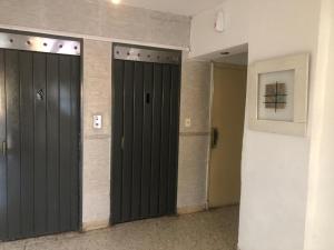 un pasillo con dos puertas negras en un edificio en Departamento de 1 ambiente en Mar del Plata