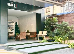 a patio with chairs and a table in a building at STAYDII serviced residence Chaengwattana in Pak Kret