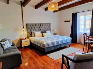 ein Schlafzimmer mit einem Bett, einem Sofa und einem Stuhl in der Unterkunft Bello atardecer - hotel boutique in Tequisquiapan