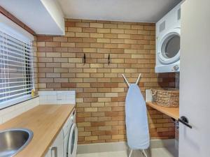 a kitchen with a sink and a brick wall at “The Block” Mooloolaba - Unit 3 in Mooloolaba