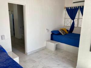 1 dormitorio con cama azul y espejo en Casa Isla Delfín, en Lo de Marcos