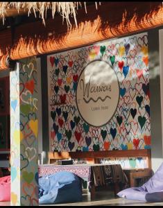 una habitación con una pared cubierta de corazones en Waiwas Hostel, en Kuta Lombok