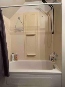 Appartement centre Lévis في ليفيس: حوض استحمام أبيض في حمام مع دش