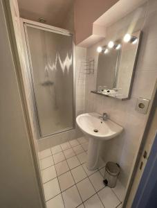 a white bathroom with a shower and a sink at Douce Demeure in Mortemart