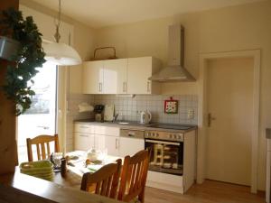 cocina con mesa y cocina con fogones en Holiday apartment Haus-Stumm, en Starkenburg