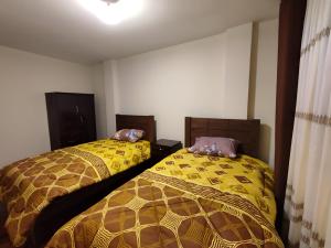 dos camas sentadas una al lado de la otra en una habitación en Departamentos a su altura en La Paz, en La Paz