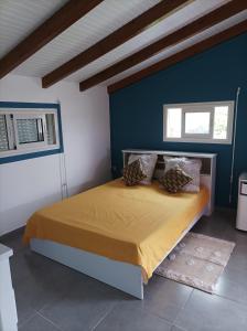 Schlafzimmer mit einem Bett mit blauer Wand in der Unterkunft Haut de villa dans le nord de la grande terre (Guadeloupe). in Anse-Bertrand