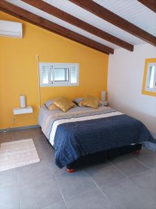 ein Schlafzimmer mit einem Bett und einer gelben Wand in der Unterkunft Haut de villa dans le nord de la grande terre (Guadeloupe). in Anse-Bertrand