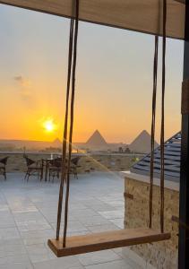 una vista de las pirámides desde el patio al atardecer en pyramids guest house en El Cairo