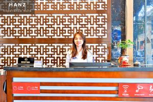 une femme assise au comptoir d'un restaurant dans l'établissement HANZ Ami Hotel, à Hanoï