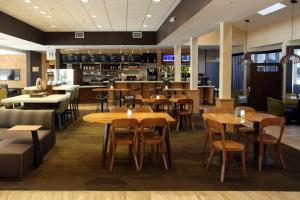 um restaurante com mesas e cadeiras de madeira em Courtyard Atlanta Northlake em Atlanta