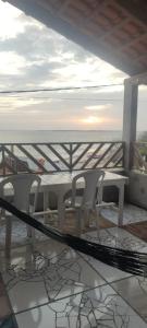 un tavolo e sedie su un balcone con vista sull'oceano di Casa Luz / Beira Mar a Tutóia