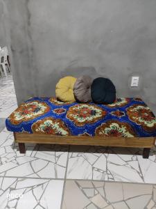 a bed with three pillows on top of it at Casa Luz / Beira Mar in Tutóia