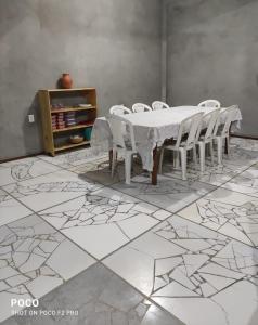 una sala da pranzo con tavolo e sedie bianchi di Casa Luz / Beira Mar a Tutóia