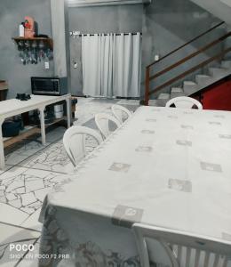una stanza con tavolo e sedie e una scala di Casa Luz / Beira Mar a Tutóia