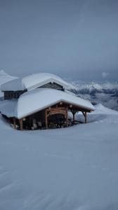 a building covered in snow on top of a mountain at CASA PIAZZALE ALPINI in Schilpario