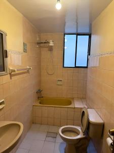 y baño con bañera, aseo y lavamanos. en Departamentos a su altura en La Paz en La Paz