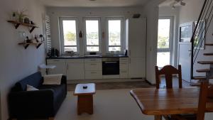 a living room with a blue couch and a kitchen at Domizil Koblenz in Koblenz