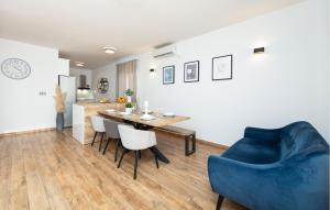 - une salle à manger avec un canapé bleu, une table et des chaises dans l'établissement 4 Bedroom Amazing Home In Solin, à Solin