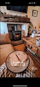 a cake on a table in a living room with a fireplace at Brynglas Cottage with Hot Tub, Anglesey. in Llanfachraeth