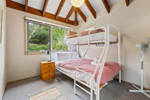 a bedroom with a bunk bed and a window at Snowgums on the Lake - Charming 4BR Home l Amazing Lake Views l Balcony in Jindabyne