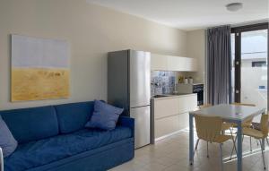 ein Wohnzimmer mit einem blauen Sofa und einem Tisch in der Unterkunft Awesome Home In Marina Di Ragusa in Marina di Ragusa