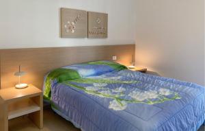 ein Schlafzimmer mit einem Bett mit einer blauen Bettdecke in der Unterkunft Awesome Home In Marina Di Ragusa in Marina di Ragusa