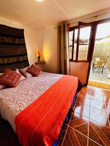 a bedroom with a bed and a large window at Posada Atacameña in San Pedro de Atacama