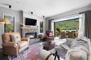 a living room with a couch and a fireplace at Elite Holiday Homes Queenstown - Arrowbrae in Arrowtown