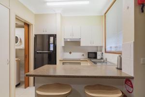 a kitchen with white cabinets and a counter top at Unit 2 8 Banks Avenue in Tweed Heads
