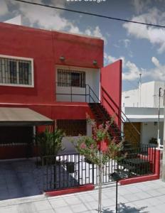 un edificio rojo con una escalera delante en Temporarios Alto Verde en Córdoba