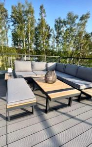 a couch and two chairs and a table on a deck at Apartament Sunset - Pobierowo Baltic Apartments - Aprent in Pobierowo