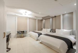 una camera d'albergo con due letti e un tavolo di Renaissance Hotel Pohang a Pohang