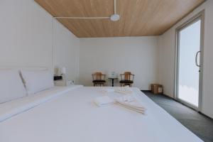 a bedroom with a white bed with two chairs at Blue Carina Hotel - SHA Plus in Phuket