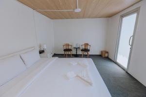 a white room with a bed and two chairs at Blue Carina Hotel - SHA Plus in Phuket Town