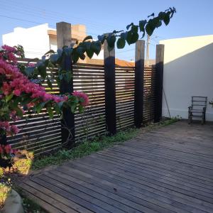 una terrazza in legno con recinzione e alcuni fiori di The Box a Passo de Torres