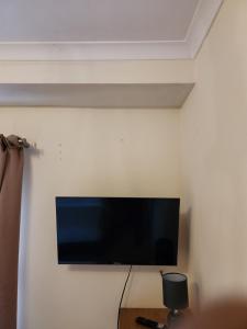 uma televisão de ecrã plano pendurada numa parede em UK CHAPS Retreat: Private Chelsea Studio em Londres