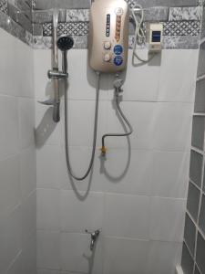 a shower in a bathroom with a blow dryer on the wall at Apo Estin homestay in Siquijor