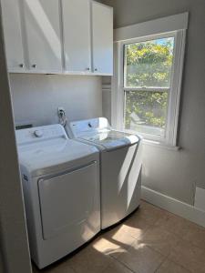 uma máquina de lavar e secar roupa branca numa cozinha com uma janela em Furnished room in beautiful, updated house close to UC Berkeley em Berkeley