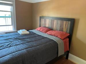 um quarto com uma cama com almofadas vermelhas e uma janela em Furnished room in beautiful, updated house close to UC Berkeley em Berkeley