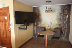 un comedor con una mesa y una pintura en la pared en Hotel-Alto Los Lirios, en Rancagua