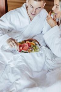 a man and woman in bed with a plate of food at Treetops Seaview Montville in Montville