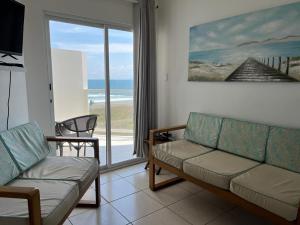 Playa La Barqueta , Las Olas Tower Front في ديفيد: غرفة معيشة مع أريكة وإطلالة على المحيط