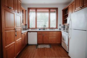 uma cozinha com armários de madeira e um frigorífico branco em Le Patrimonial em Sainte-Agathe-des-Monts