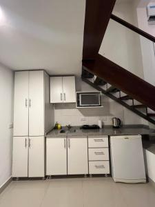 a kitchen with white cabinets and a microwave at Solares, Departamento zona centro in La Rioja