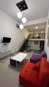 a living room with a red couch and a table at Solares, Departamento zona centro in La Rioja